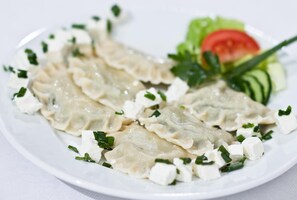 Un plato de albóndigas con vegetales y queso.