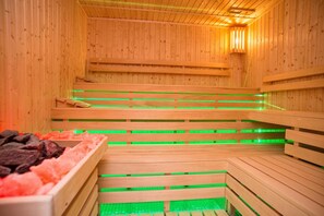 Una sauna con bancos de madera e iluminación verde.