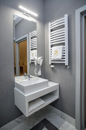 A modern bathroom with a white sink, a mirror, and a towel rack with towels. - Ba Oniowa (Wyszków)