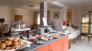 A buffet area with various food items, a coffee machine, and a sign indicating a no smoking area.