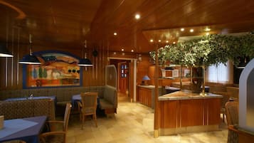 Ein Restaurant mit Sitzgelegenheiten in Form von Boxen, Tischen und einer Theke.