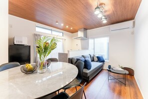 A modern living room with a round dining table, a sofa, and a coffee table. - Fully Renovated / 1 Station from Ikebukuro / 6 Beds (Toshima-ku)