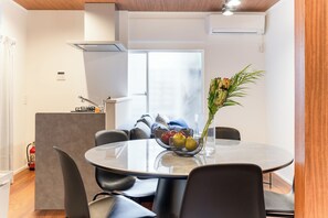 A modern dining area with a round table, black chairs, and a vase with flowers. - Fully Renovated / 1 Station from Ikebukuro / 6 Beds (Toshima-ku)