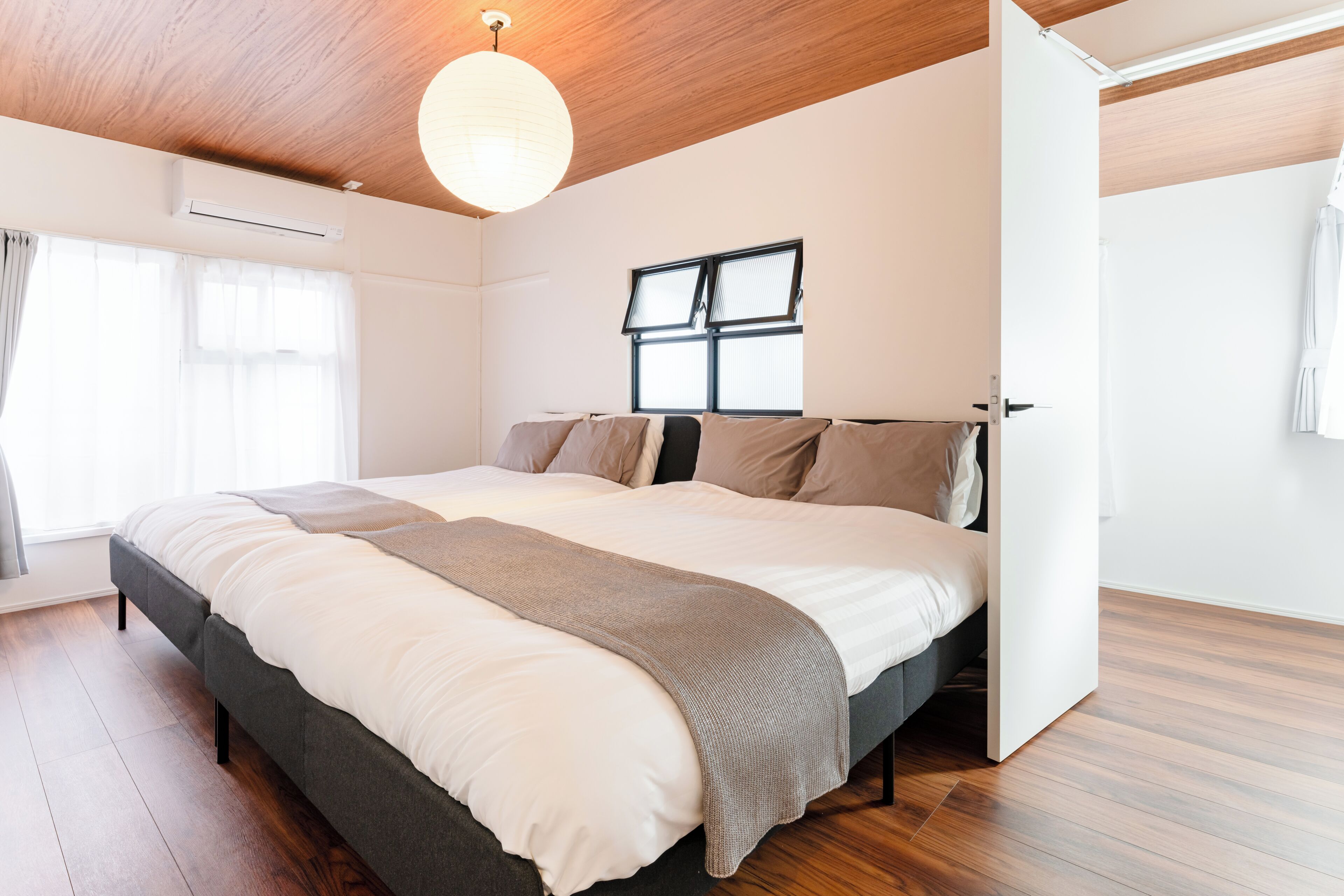 Ein Schlafzimmer mit einem Bett, einem Fenster und einer Deckenleuchte.