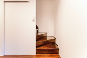 A staircase with wooden steps leading to a white door. - Fully Renovated / 1 Station from Ikebukuro / 6 Beds (Toshima-ku)