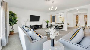 A modern living room with a sofa set, a coffee table, and a flat-screen TV. - 4000SF LUXE HOME｜Near Strip｜PoolTable｜TV in ALL Rm (Las Vegas)