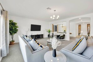 Uma sala de estar moderna com sofá, mesa de centro e televisão de tela plana.
