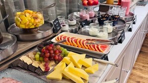 Ein Buffet mit verschiedenen Speisen, darunter Obst, Käse und Fleisch.