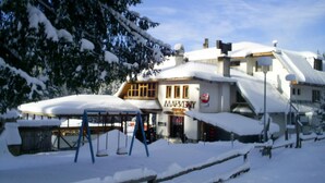 A snow-covered building with a sign that reads 'MARKETPLACE FAMILY RESTAURANT.' - Family Hotel Markony (Smolyan)