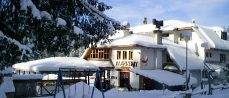 Un edificio cubierto de nieve con un letrero que dice 'MARKETPLACE FAMILY RESTAURANT'.