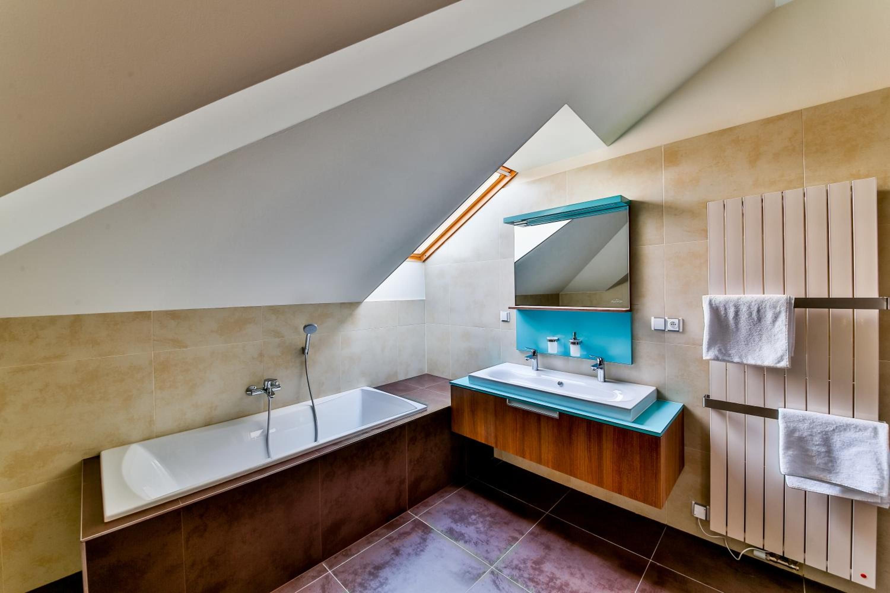 A modern bathroom with a freestanding bathtub, a vanity with a mirror, and a towel rack.