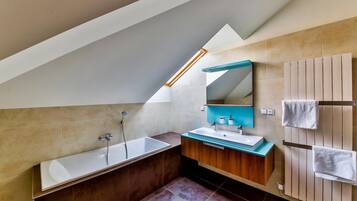 A modern bathroom with a freestanding bathtub, a vanity with a mirror, and a towel rack.