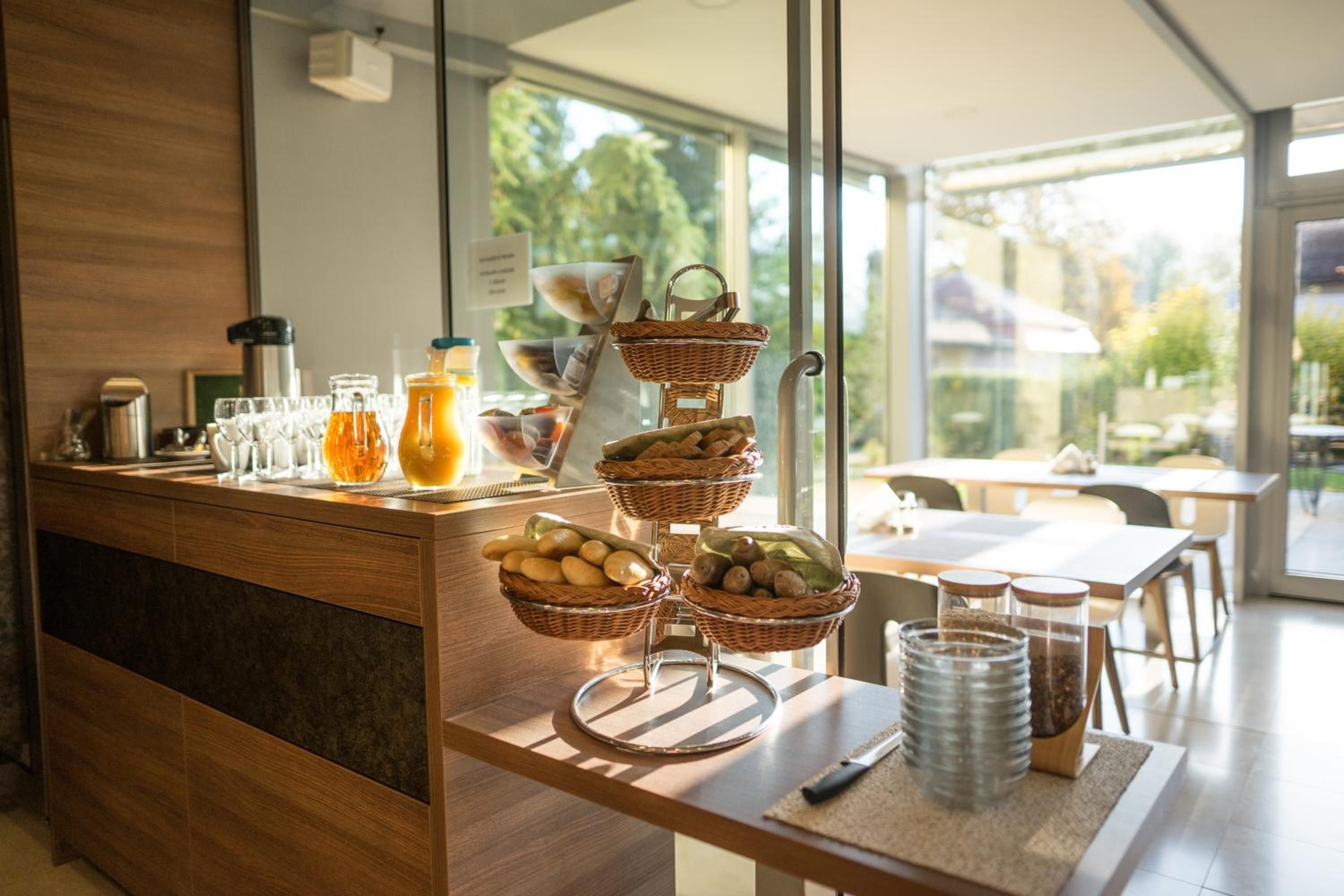 A breakfast buffet with wicker baskets, a coffee station, and a view of the outdoors.