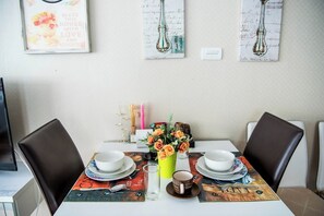 Ein Esstisch ist gedeckt mit Tellern, Tassen und einer Blumenvase.