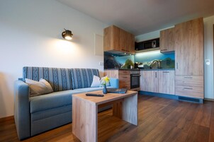 A compact living space with a sofa, a coffee table, and a kitchenette.