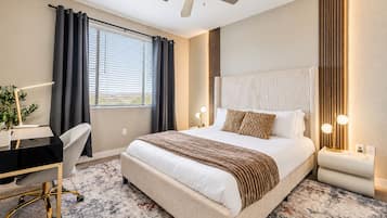 Una habitación de hotel con cama, escritorio, silla y ventilador de techo.