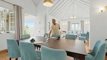 A spacious dining area with a high ceiling and modern furniture.