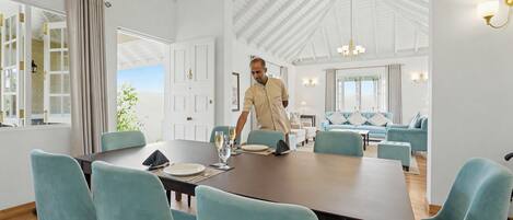 Un comedor amplio con techo alto y mobiliario moderno.