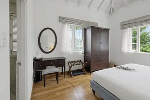 A bedroom with a bed, a dresser, a desk with a chair, a bench, and a mirror. - Aadya Tea Bangalows By Aahaasa (Upcot)