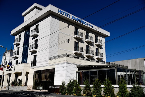 Un hotel de varios pisos con un letrero llamativo que dice 'HOTEL IMPERIO'.