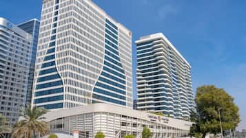 A modern building with a curved facade, multiple floors, and a prominent entrance area.