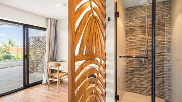 Un baño moderno con cabina de ducha de vidrio, un panel decorativo de madera y vistas al exterior.