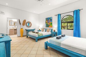 Una habitación con dos camas, un escritorio, un espejo y una ventana con cortinas.