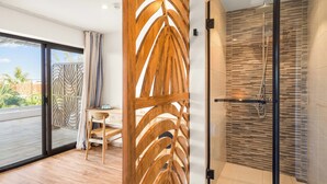 Un baño moderno con cabina de ducha de vidrio, un panel decorativo de madera y vistas al exterior.