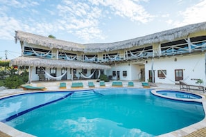 A resort with a swimming pool, thatched-roof structures, and lounge chairs. - 7 Beaufort - Kitesurf Pousada (Itarema)