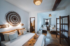 A hotel room with a bed, a sitting area, and a view of the bathroom.