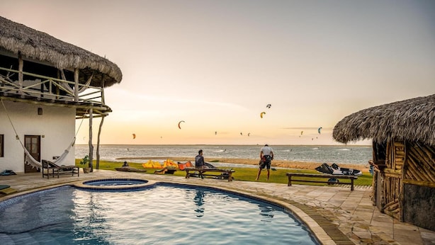 Ein Pool mit Blick auf den Strand und Kitesurfern.