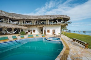 A resort with a pool, thatched-roof structures, and a view of the sea. - 7 Beaufort - Kitesurf Pousada (Itarema)