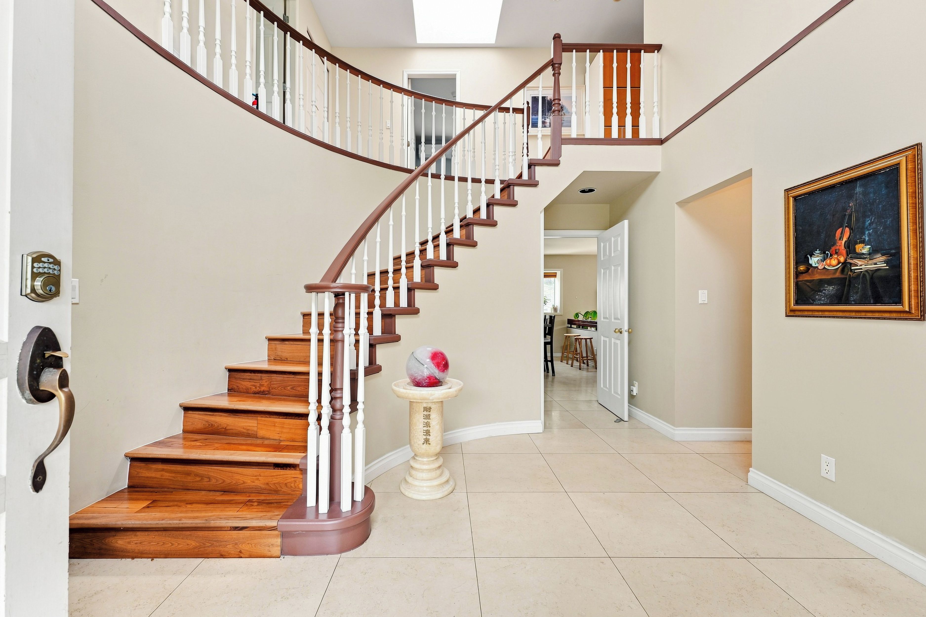A wooden staircase with white balusters and a brown handrail leading to an upper floor.