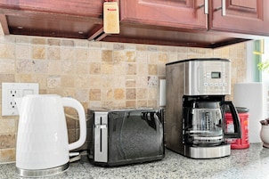 Una cocina con cafetera, tostadora y hervidor.