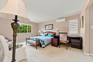 A bedroom with a bed, bedside tables, a desk, and a chair.