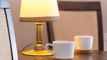 A table with a lamp and two cups.