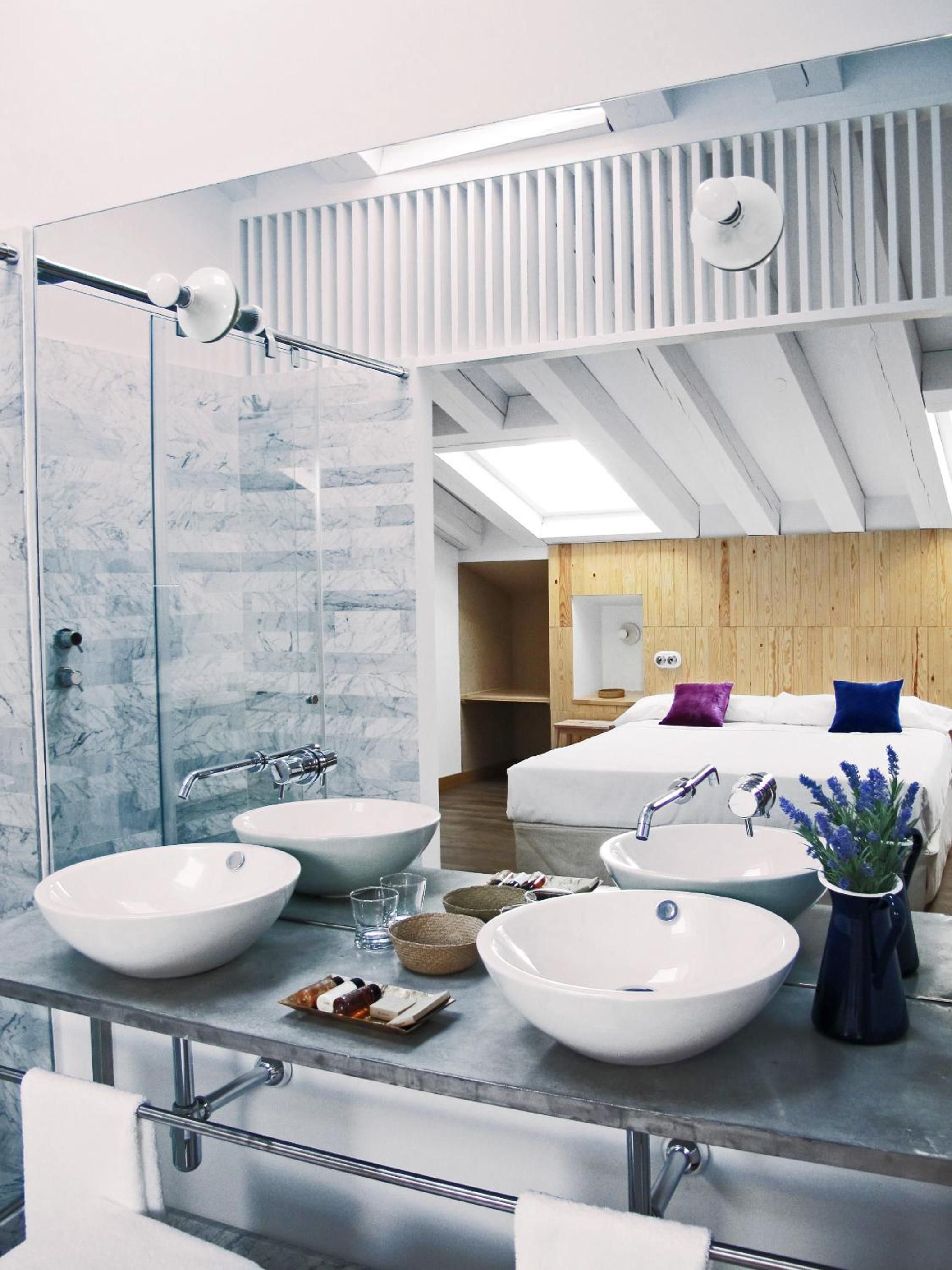 A modern bathroom with two large sinks, a mirror, and a shower area.