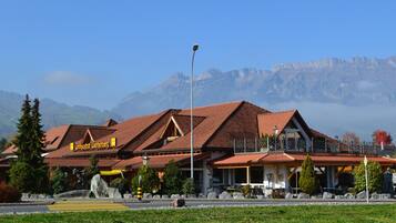 A hotel with a red-tiled roof, a sign reading 'Landgasthof Werdenberg,' and a mountain backdrop.