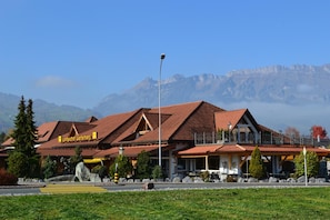Un hotel dal tetto in tegole rosse, con una insegna che riporta 'Landgasthof Werdenberg' e uno sfondo montuoso.