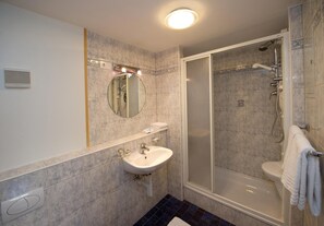 Un bagno con lavandino, specchio e doccia.