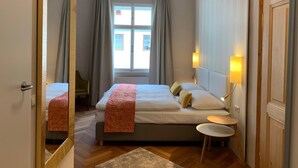 Habitaci ón de hotel con cama, mesita de noche, lámpara y ventana con cortinas.