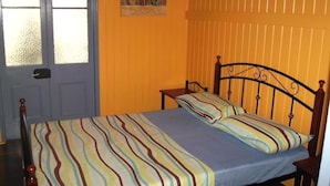 Una habitación con una cama, una ventana y una puerta.