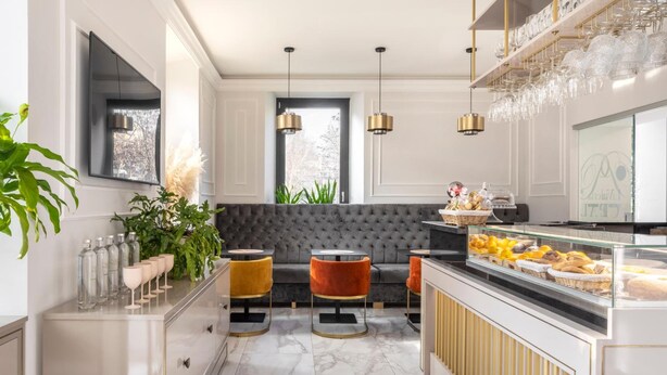 A modern kitchen with a marble countertop, a built-in oven, and a glass display case with pastries. - Livia Valeria Palace (Rome)