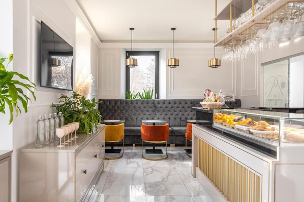 A modern kitchen with a marble countertop, a built-in oven, and a glass display case with pastries. - Livia Valeria Palace (Rome)