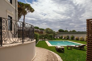 A swimming pool with lounge chairs and a paved patio area. - Livia Valeria Palace (Rome)