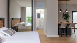 A modern hotel room with a large bed, a desk with two chairs, and a view of the outdoors. - Livia Valeria Palace (Rome)