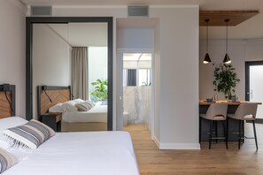 A modern hotel room with a large bed, a desk with two chairs, and a view of the outdoors. - Livia Valeria Palace (Rome)
