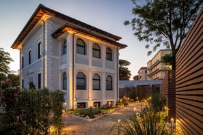 A multi-story building with a symmetrical facade, arched windows, and a central entrance. - Livia Valeria Palace (Rome)