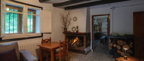 Una habitación acogedora con chimenea, una mesa de comedor y un sofá.