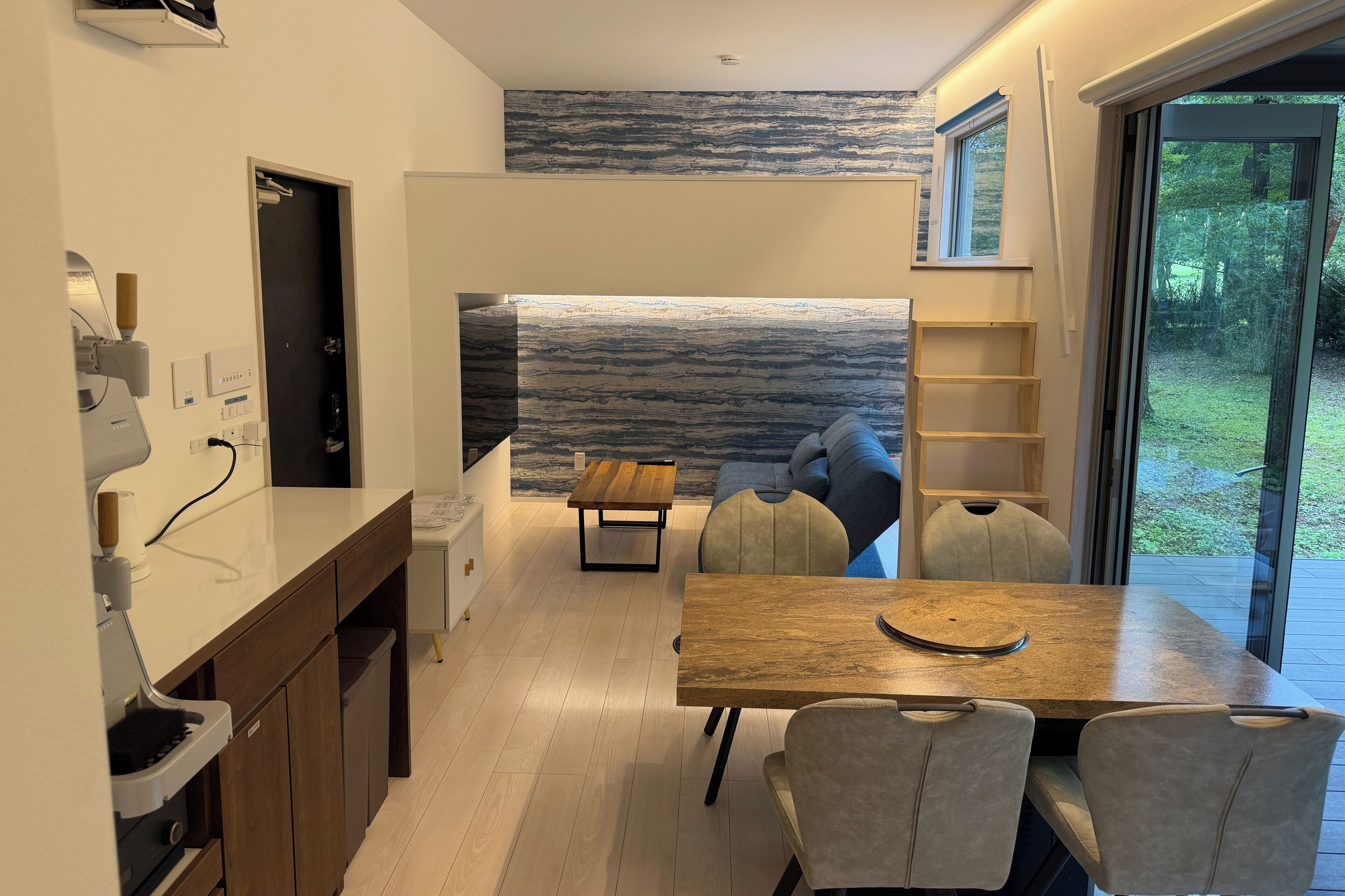 A modern kitchen with a dining area, a built-in bench, and a view of the outdoors.